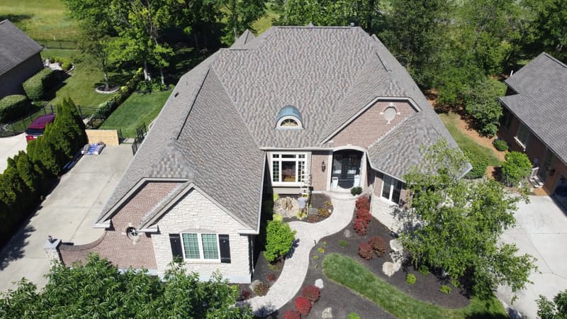 Large home with brown shingle roof, aerial view