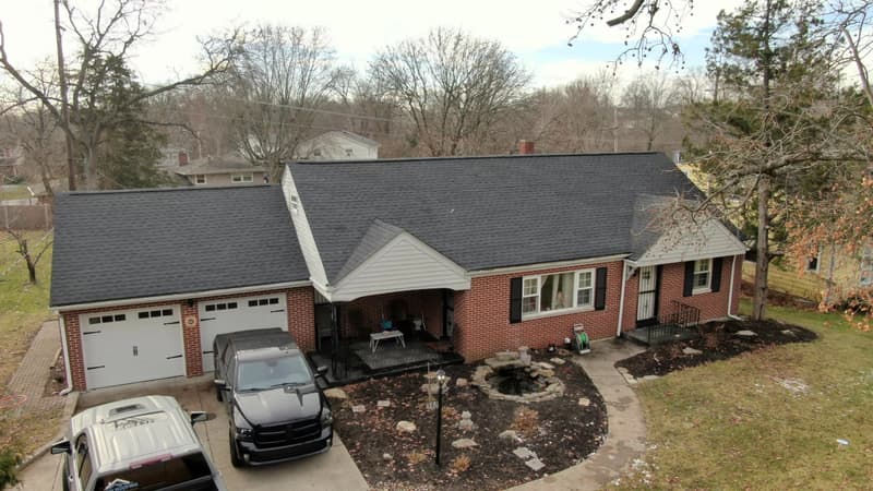 Brick ranch home with dark shingle roof